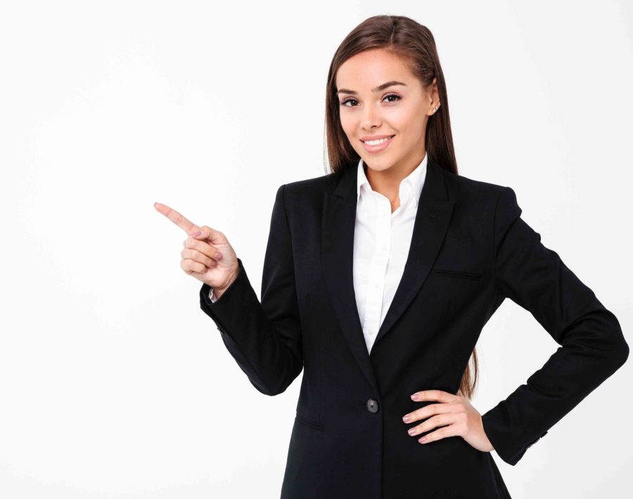 Image of happy business woman standing isolated over white background. Looking camera pointing to copyspace.